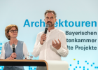 Zwei Personen sprechen an einem Podium
