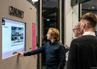 Besucher der Begleitausstellung schauen auf einen Bildschirm