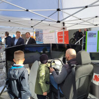 Virtuell auch selbst ans Steuer: Eine Familie testet einen Simulator für Transport- und Logistikfahrzeuge bei der Veranstaltung "Wir bewegen Bayern" in Deggendorf.