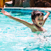 Ein Junge spielt in einem Freibad © Shutterstock