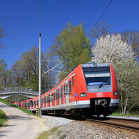 Zwei Triebwagen der Baureihe ET 423 sind als S2 Altomünster -- Erding unterwegs und passieren hier kurz vor Erreichen des Bahnhofes Erdweg den Petersberg mit neu gebauter Fußgängerbrücke im Ortsteil Eisenhofen.